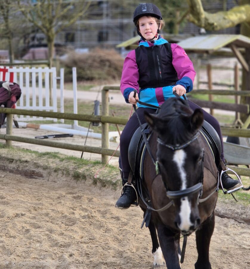 Tochter beim Reiten auf dem Pony